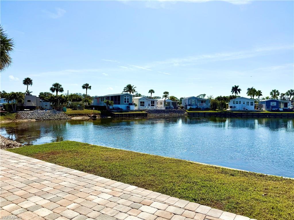 564 Cattleya Refuge, Unit 564 Naples, FL 34114 - Photo 8 of 50 a view of a lake with boats and trees in the background
