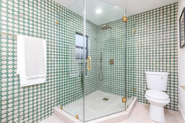 a bathroom with a toilet and a shower