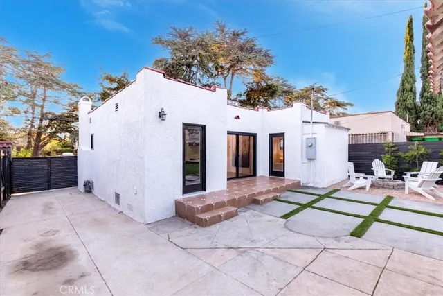 a view of a white house with a yard and plants