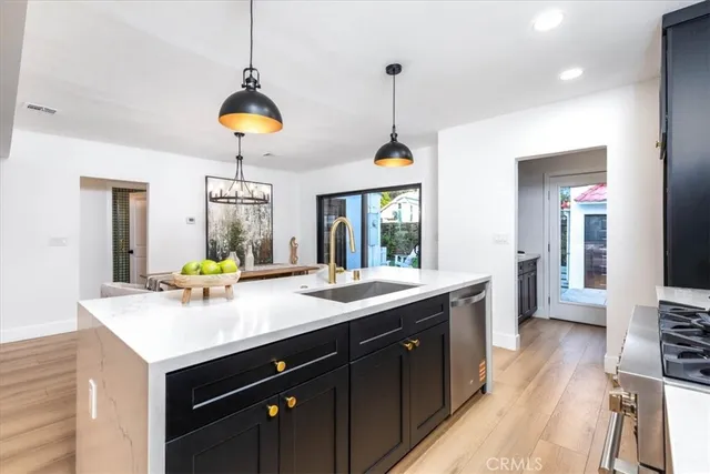 a kitchen with a sink a counter space appliances and cabinets