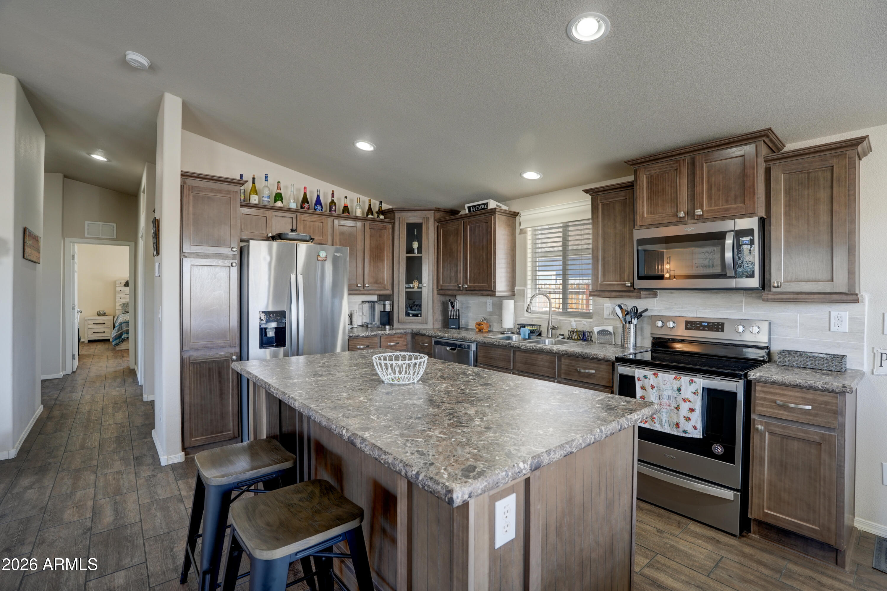 1159 Wheeler Road Camp Verde, AZ 86322 - Photo 7 of 13 a kitchen with stainless steel appliances granite countertop a kitchen island hardwood floor and wooden cabinets
