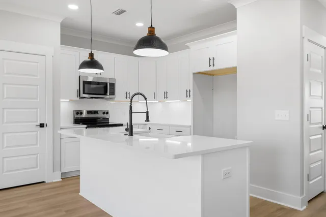 a kitchen with stainless steel appliances a stove a sink and a microwave