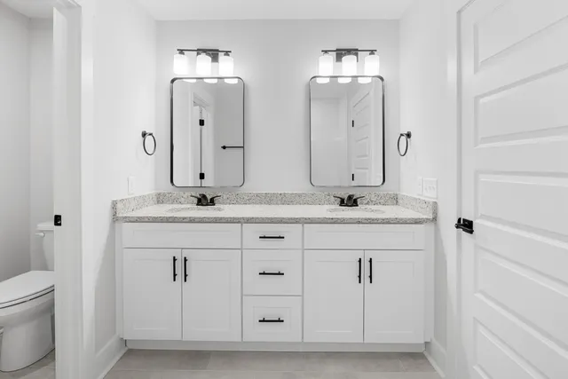a bathroom with double sink and a mirror