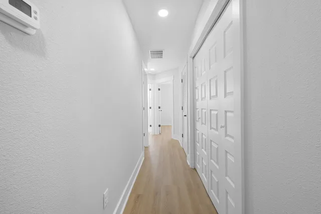 a view of a hallway with wooden floor and staircase