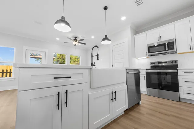 a kitchen with stainless steel appliances granite countertop a sink a stove and a refrigerator