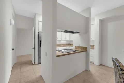 a kitchen with granite countertop white cabinets and a stove