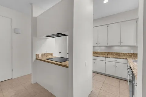 a kitchen with granite countertop a sink stainless steel appliances and cabinets