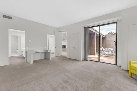 an empty room with furniture and floor to ceiling windows