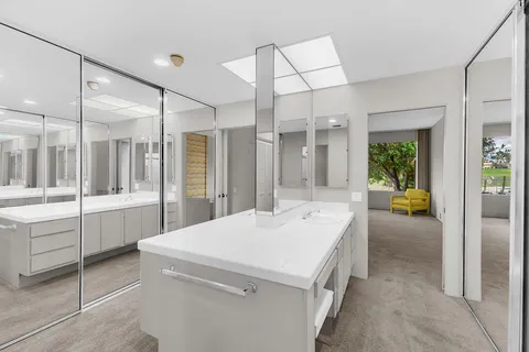 a living room with couches and a dining table with wooden floor