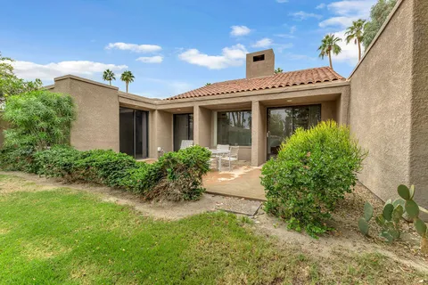 a view of a house with a yard and potted plants