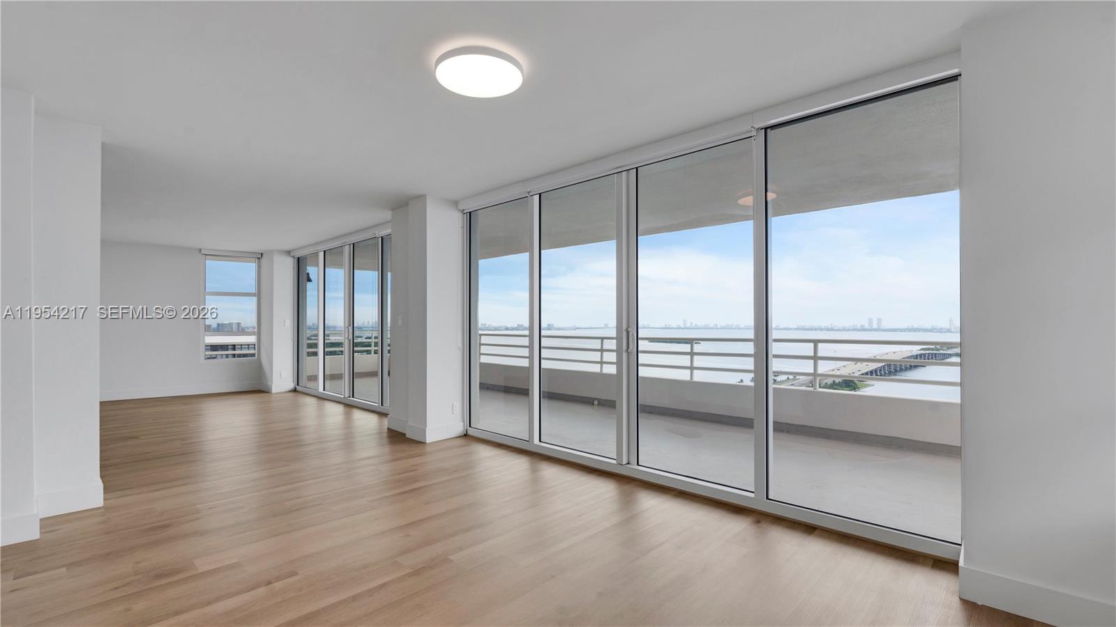 555 Northeast 34th Street, Unit 2201 Miami, FL 33137 - Photo 13 of 46 a view of an empty room with wooden floor and a window