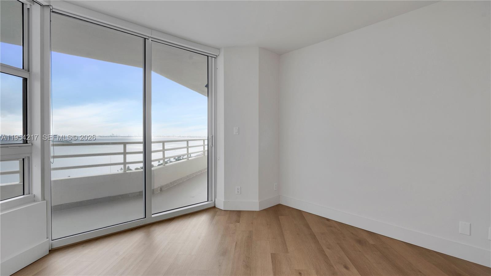 555 Northeast 34th Street, Unit 2201 Miami, FL 33137 - Photo 33 of 46 an empty room with wooden floor and windows