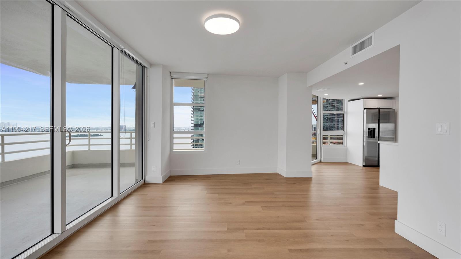 555 Northeast 34th Street, Unit 2201 Miami, FL 33137 - Photo 10 of 46 a view of empty room with wooden floor and floor to ceiling window