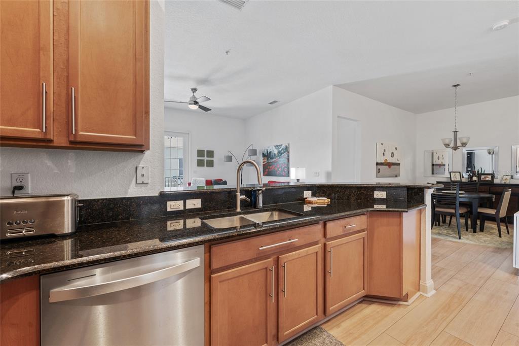 1819 Common Way Road, Unit 203 Orlando, FL 32814 - Photo 9 of 23 a kitchen with stainless steel appliances granite countertop a sink and cabinets