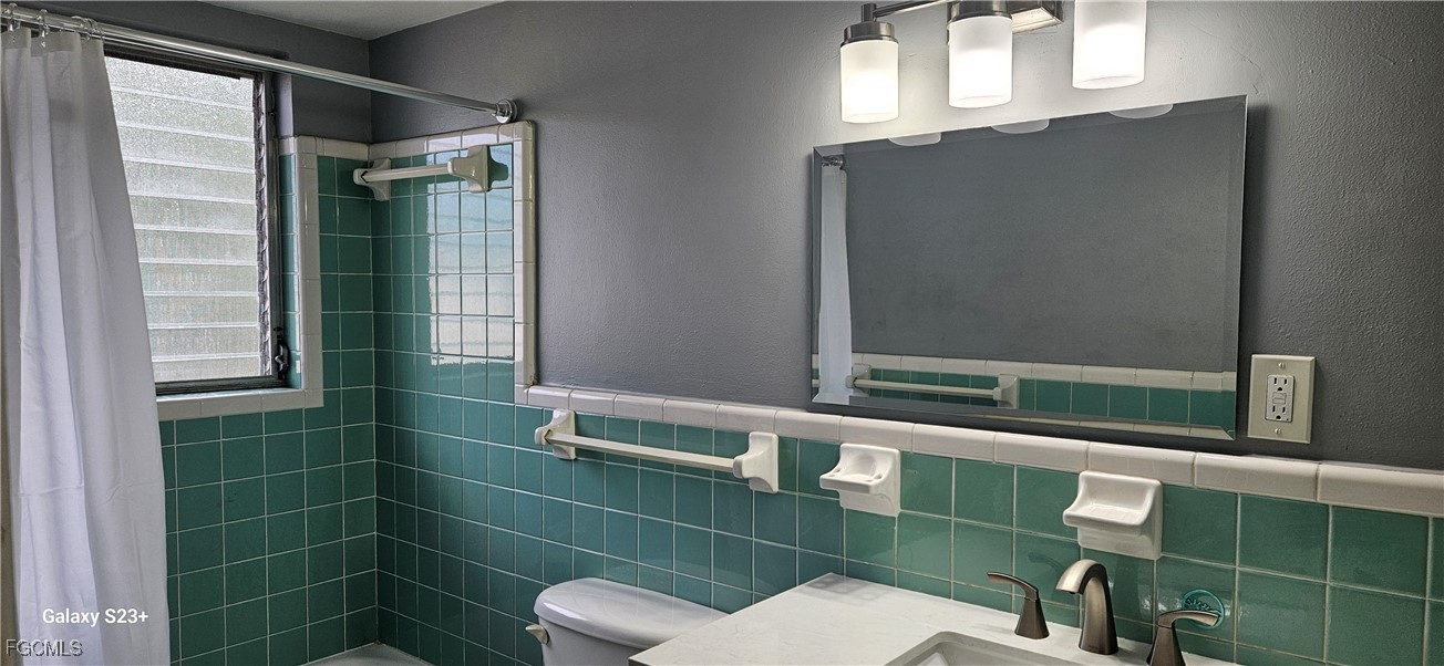 2544 First Street, Unit 202 Fort Myers, FL 33901 - Photo 17 of 20 a bathroom with a toilet a sink and mirror