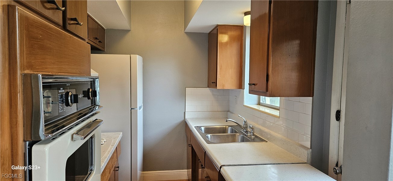 2544 First Street, Unit 202 Fort Myers, FL 33901 - Photo 7 of 20 a kitchen with a refrigerator and a sink