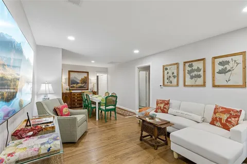 a view of a dining room with furniture a kitchen and wooden floor