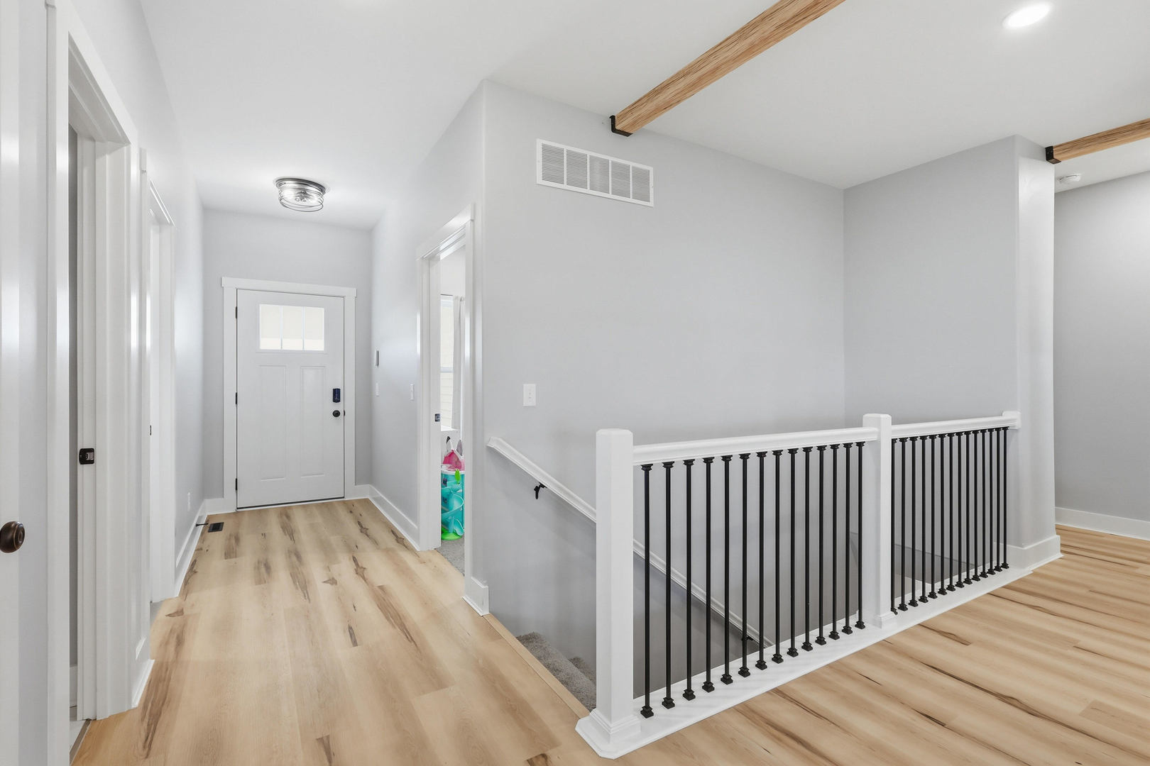 6779 Genesis Way Bettendorf, IA 52722 - Photo 3 of 36 a view of a hallway with wooden floor and a bathroom