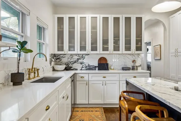 a kitchen with cabinets a sink and chairs