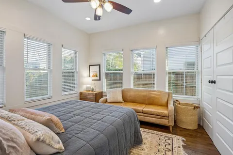 a bedroom with a bed and a couch next to a window