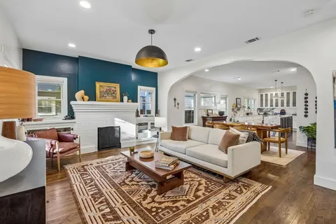 a living room with furniture a fireplace and kitchen view