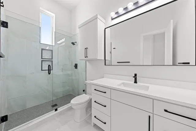 a bathroom with a sink a toilet and shower