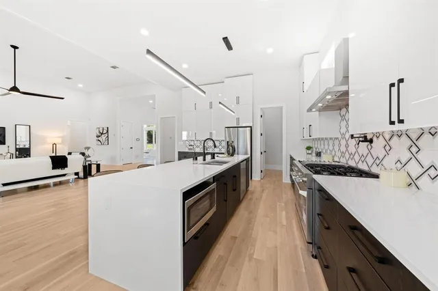 a large kitchen with stainless steel appliances lots of counter space and a sink