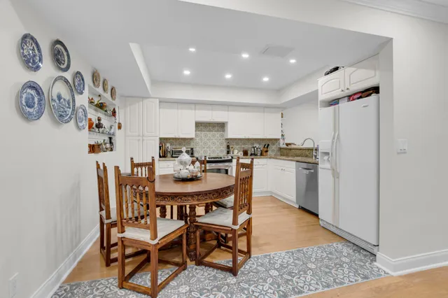 a kitchen with a dining table chairs and white stainless steel appliances