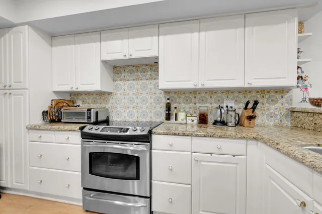 a kitchen with granite countertop white cabinets and white appliances