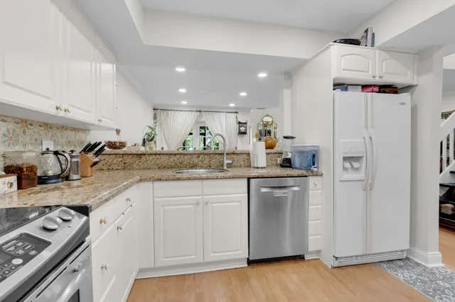 a kitchen with white cabinets and appliances