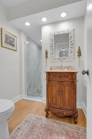a bathroom with a granite countertop sink a mirror and shower