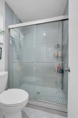 a bathroom with a toilet and a shower