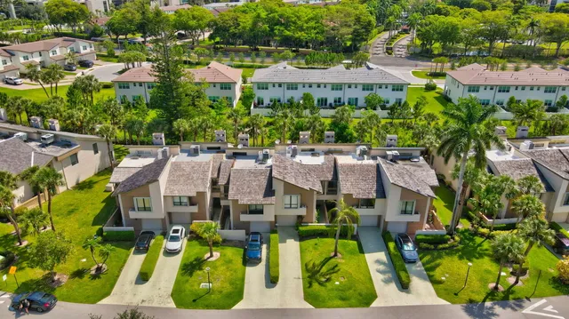 an aerial view of residential houses with outdoor space and trees