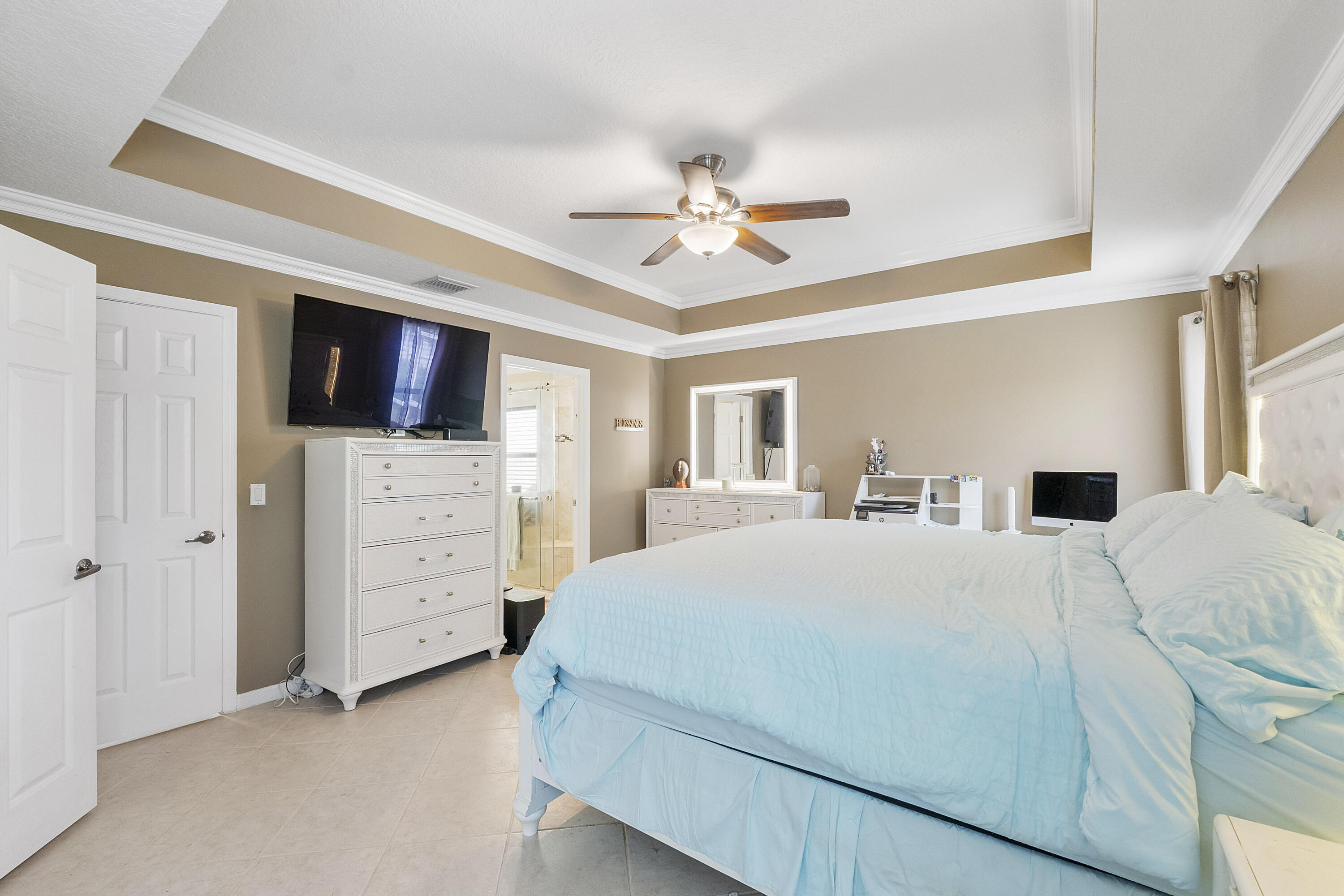 12328 St Simon Drive Boca Raton, FL 33428 - Photo 21 of 52 a bedroom with a bed a dresser and a flat screen tv