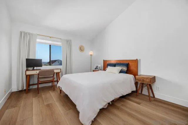 a bedroom with a bed and wooden floor