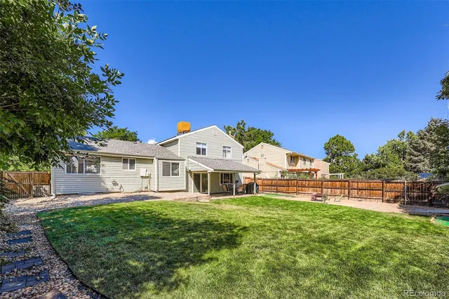 a front view of house with yard and trees in the background