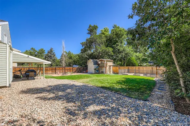a view of a house with backyard and sitting area