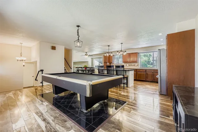 a very nice looking dining room with kitchen island a stove a table and chairs