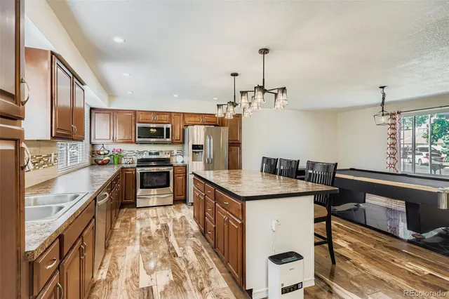 a kitchen with granite countertop a sink stove and refrigerator