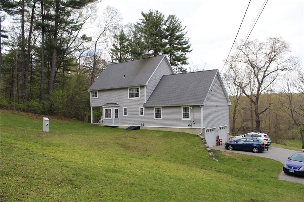 38 Page Road Pomfret, CT 06259 - Photo 1 of 1 a front view of a house with a garden and trees