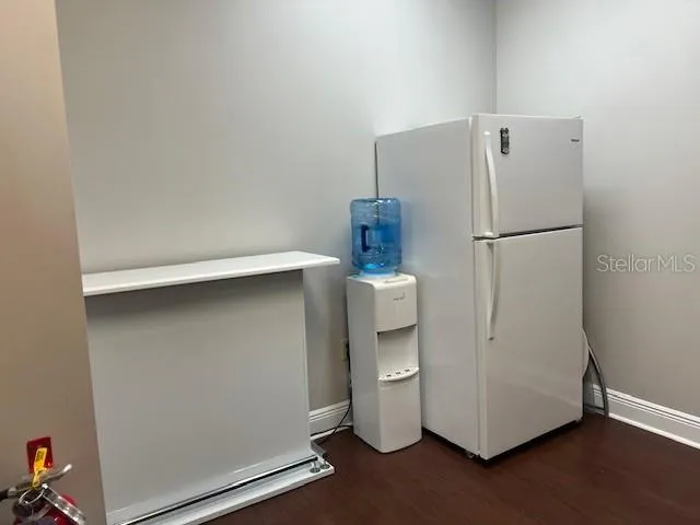 a white refrigerator freezer and a stove sitting inside of a kitchen