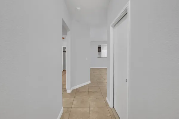an empty room with windows and chandelier fan