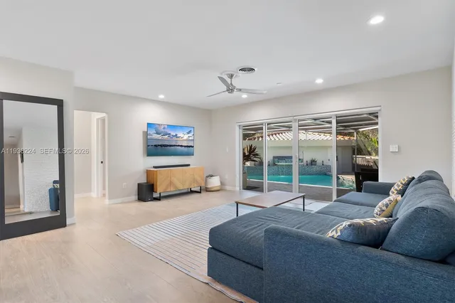 a dining room with wooden floor a chandelier a glass table and chairs