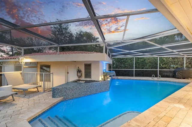 a view of a house with pool and chairs in patio