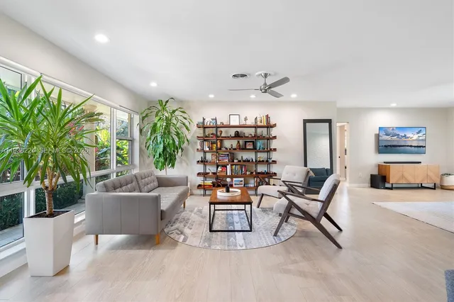 a dining room with furniture and a floor to ceiling window