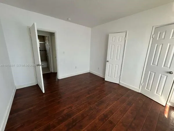 an empty room with wooden floor and closet