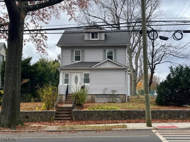 a front view of a house with a yard garage and tree s