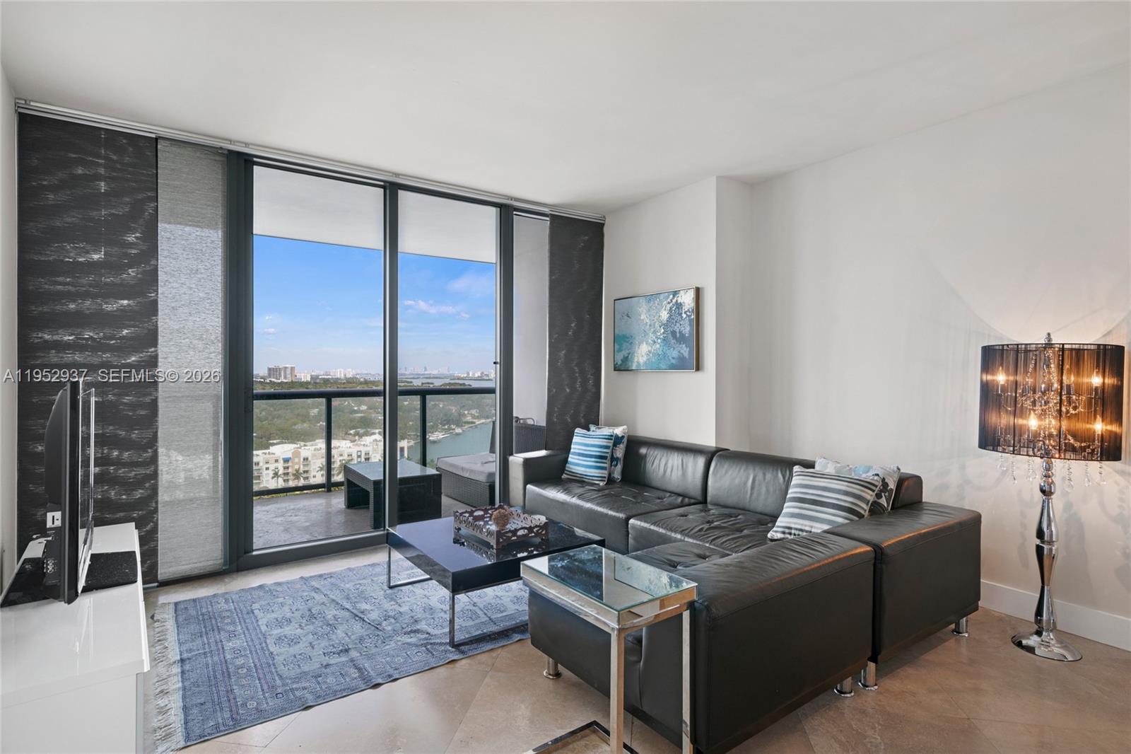 601 Northeast 36th Street, Unit 1704 Miami, FL 33137 - Photo 4 of 18 a living room with furniture and a flat screen tv