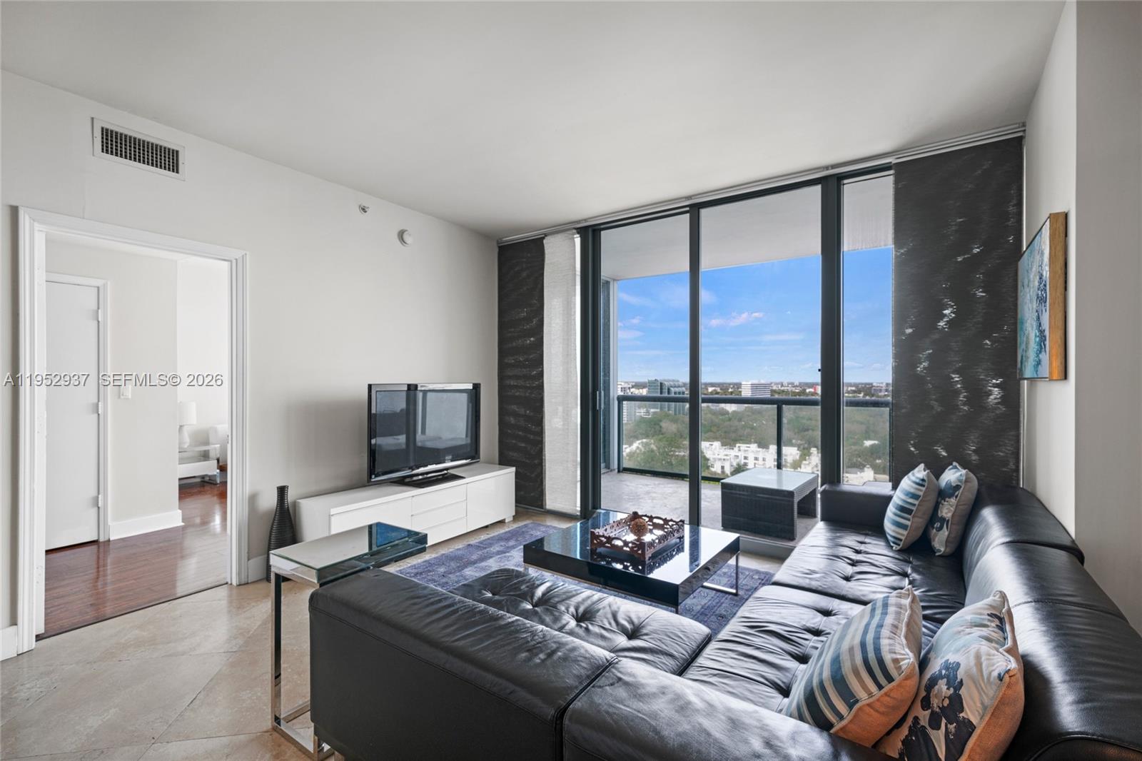601 Northeast 36th Street, Unit 1704 Miami, FL 33137 - Photo 5 of 18 a living room with furniture and a flat screen tv