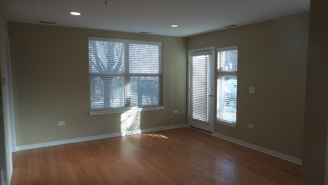 1244 West Monroe Street, Unit 1 Chicago, IL 60607 - Photo 3 of 25 an empty room with wooden floor and windows